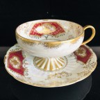 hand decorated burgundy tea cup and saucer