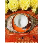 Unique bright red orange tea cup and saucer